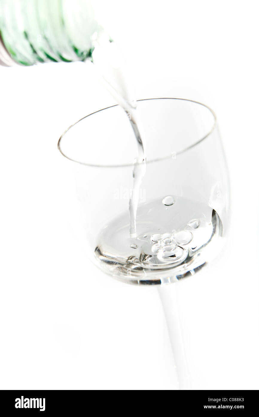 A glass of Sambuca being poured on a white background. Stock Photo