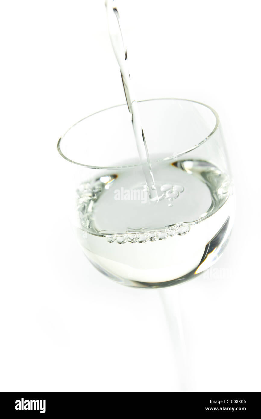 A glass of Sambuca being poured on a white background. Stock Photo