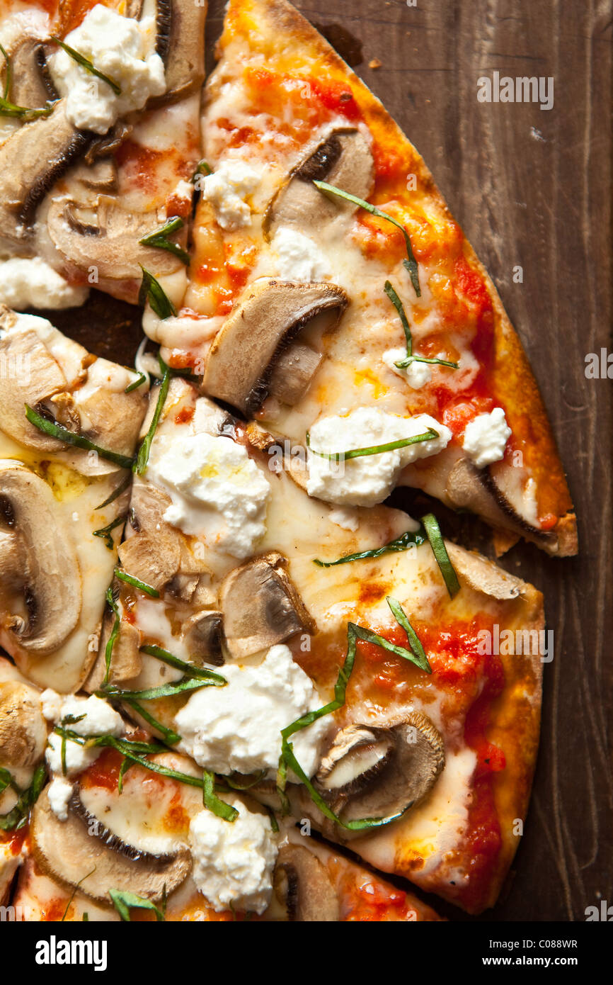 Thin and crispy crust Pizza with Mozzarella, Mushrooms, Goat Cheese and Basil prepared by Gianni Scappin, Chef/Owner of Cucina W Stock Photo