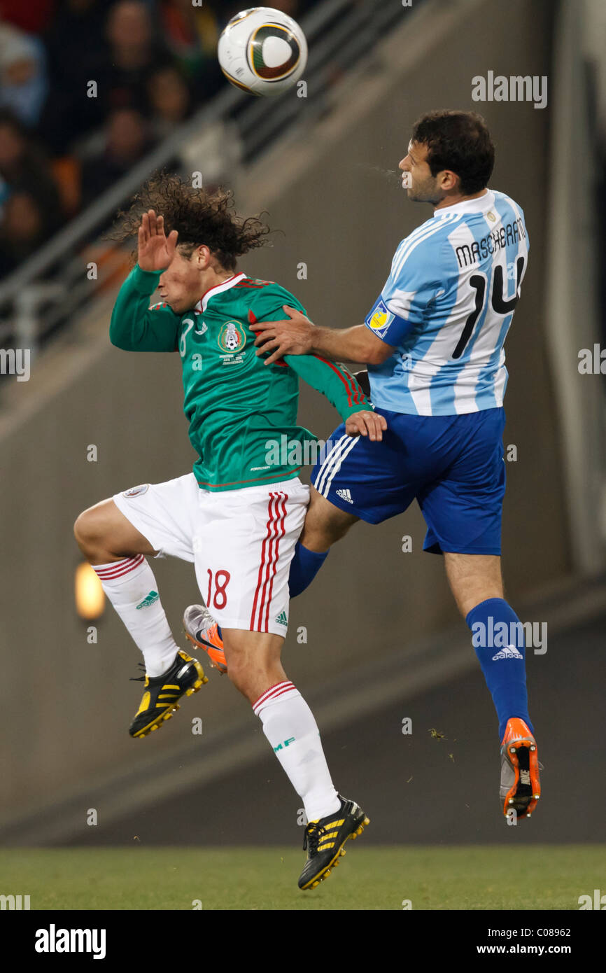 Andres Guardado of Mexico (l) and Javier Mascherano of Argentina (r) battle for a header during a 2010 World Cup round 16 match. Stock Photo