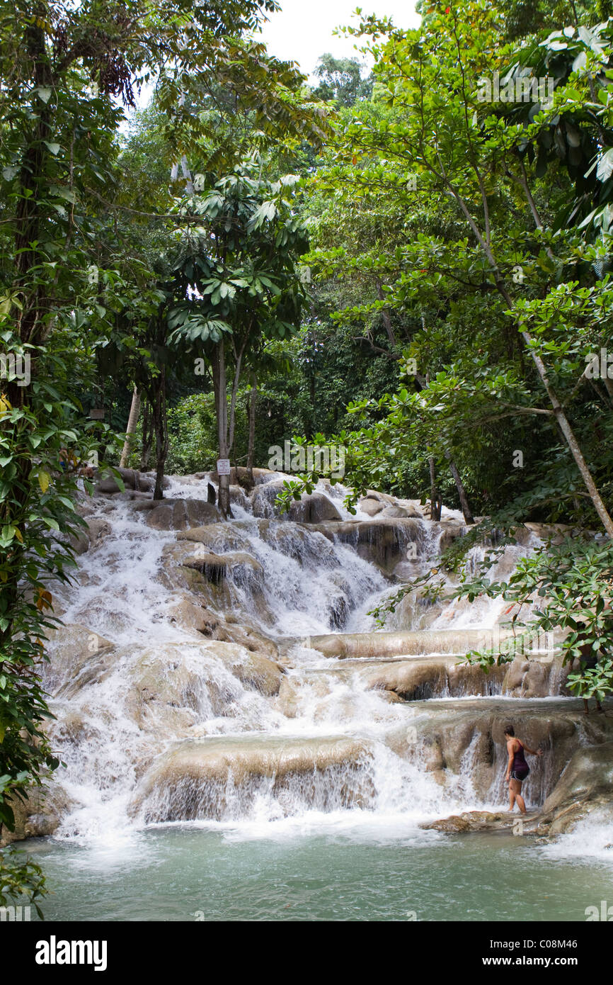 Young female tourist starts to climb Dunn's River Falls in Jamaica