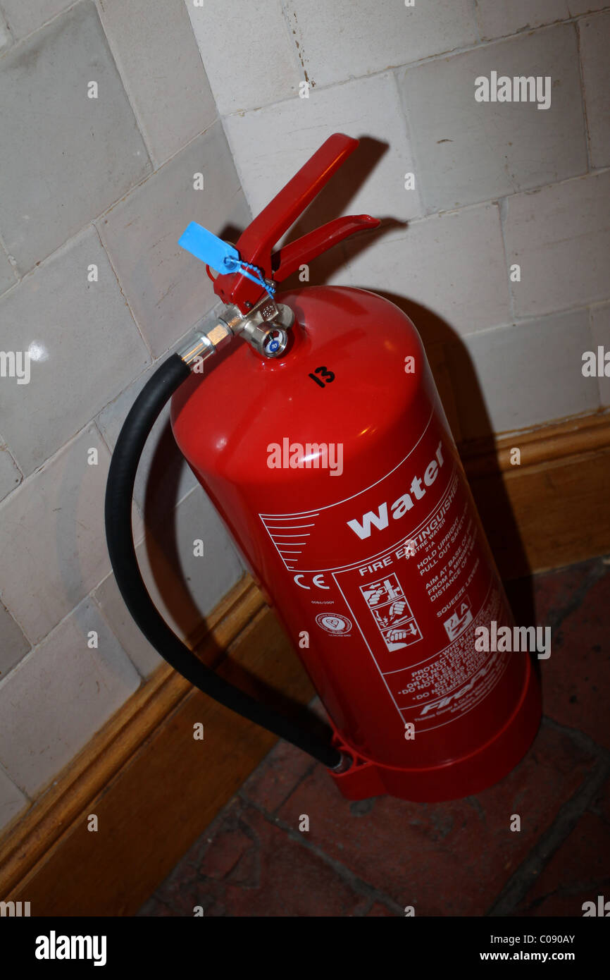 A bright red fire extinguisher pictured in a hallway in a home in