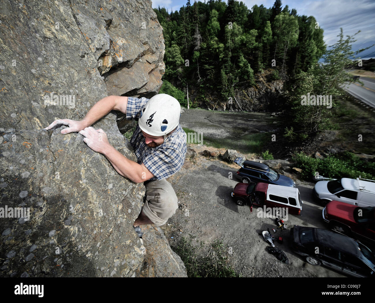 Man finishes a difficult rock climb along Turnagain Arm near Anchorage