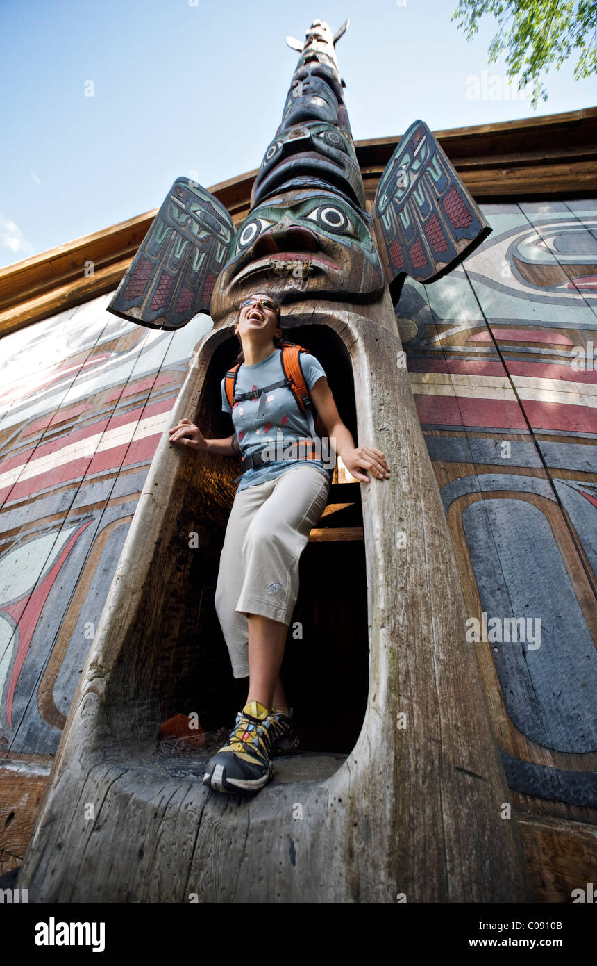 Woman explores the clan house at Totem Bight State Historical Park near Ketchikan, Southeast Alaska, Summer Stock Photo