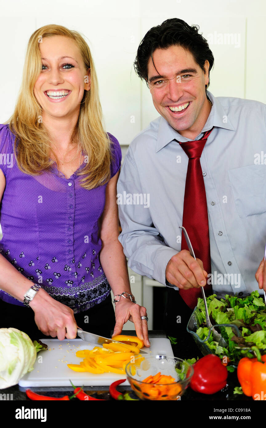 Young couple cutting vegetables for a salad Stock Photo - Alamy