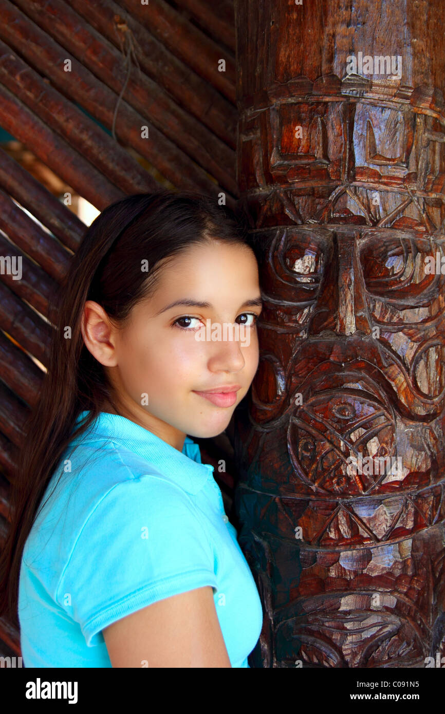 Latin mexican teen girl smile with indian wood totem Stock Photo