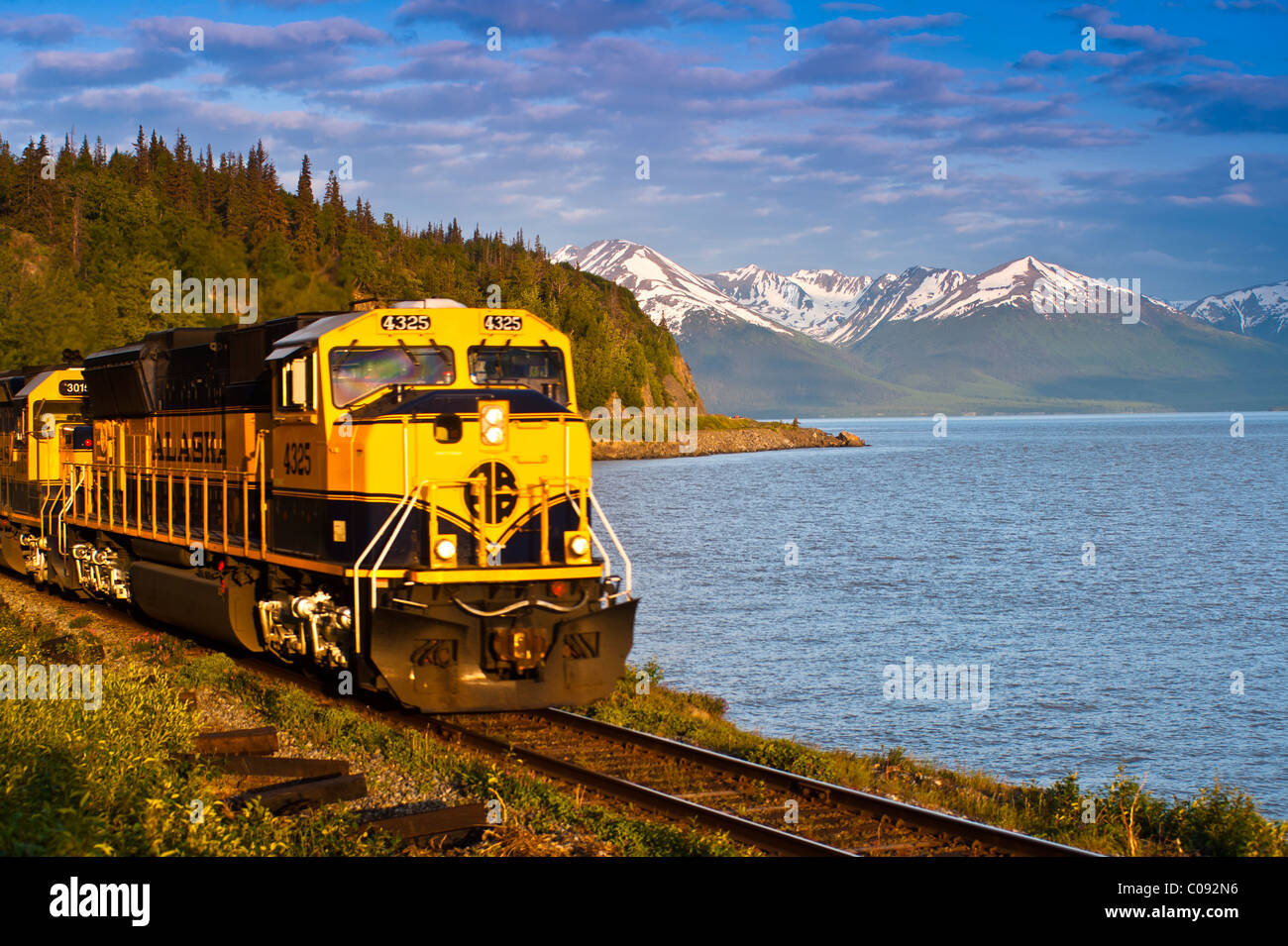 An Alaska Railroad passenger train rounds a corner along Turnagain Arm near Bird Creek, Southcentral Alaska, Summer Stock Photo