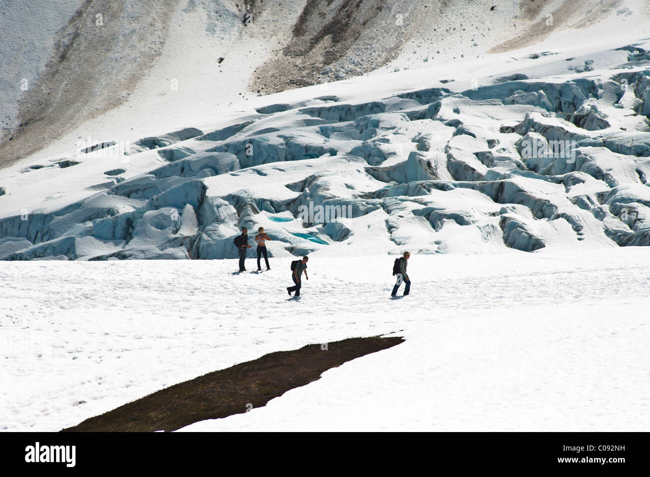 Hikers hiking on the snow covered Harding Icefield Trail with Exit Glacier in the background, Kenai Fjord National Park, Alaska Stock Photo