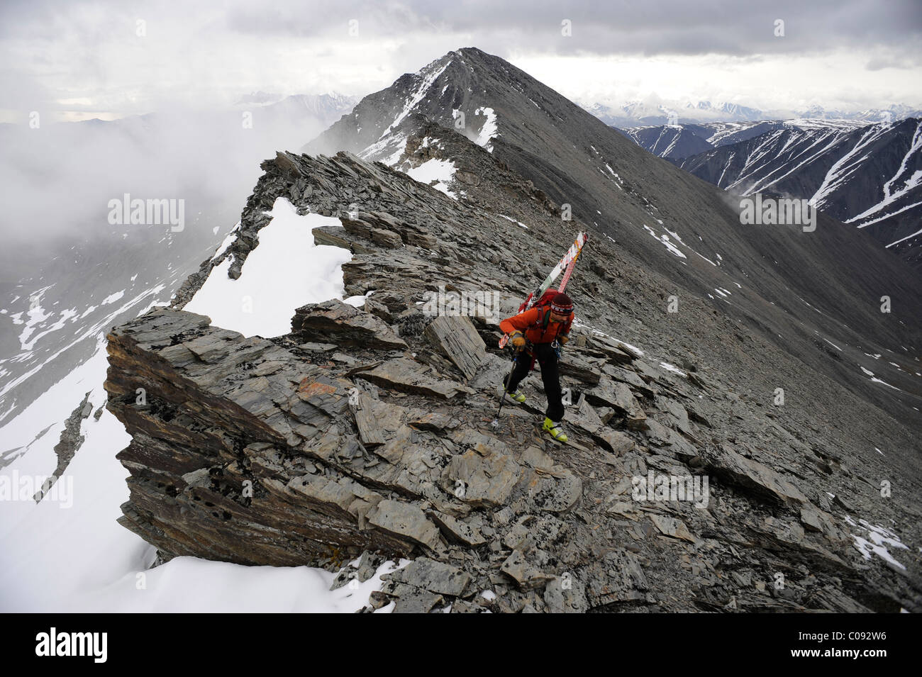 Backpacker climbs the West Ridge of Mt. Chamberlin in the Brooks Range, ANWR, Arctic Alaska, Summer Stock Photo