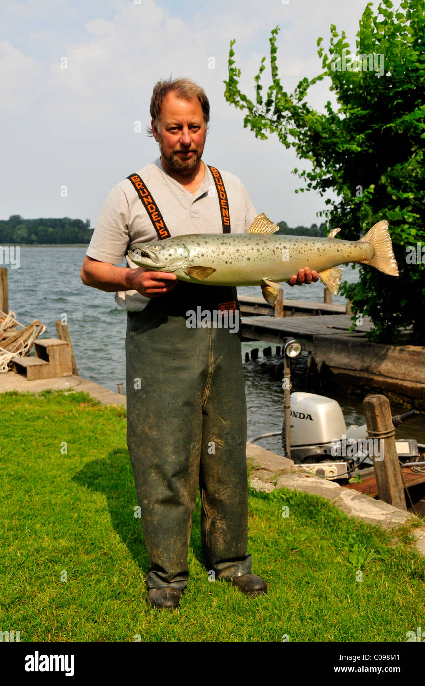 Fisherman Lex Thomas with a stuffed brown trout (Salmo trutta lacustris), Fraueninsel island, Chiemsee lake, Chiemgau, Bavaria Stock Photo
