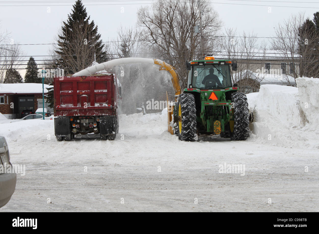 Snow plow blowing snow into dump truck Stock Photo Alamy