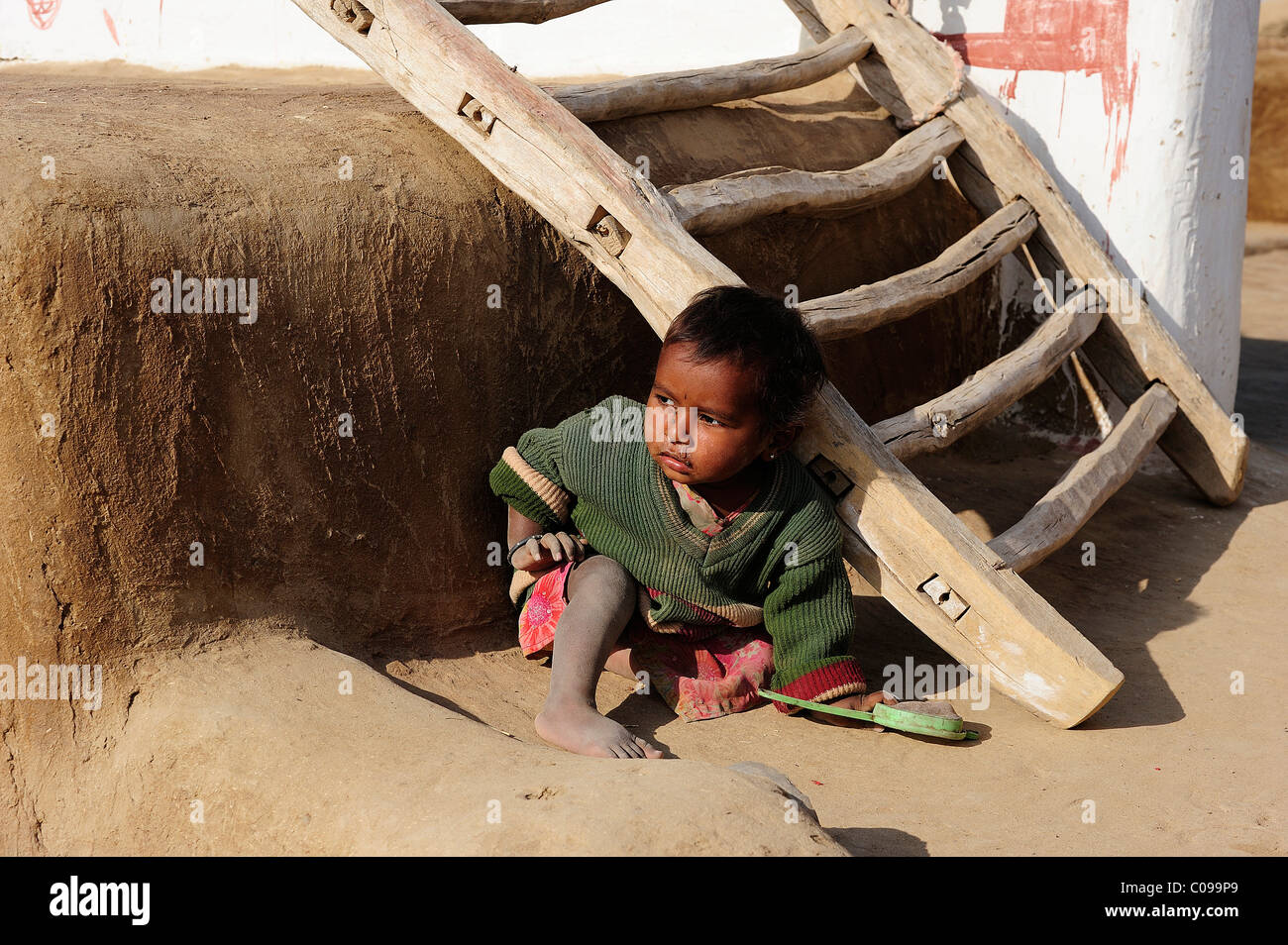 Little boy playing at an entrance ladder, Thar Desert, Rajasthan, North India, India, Asia Stock Photo