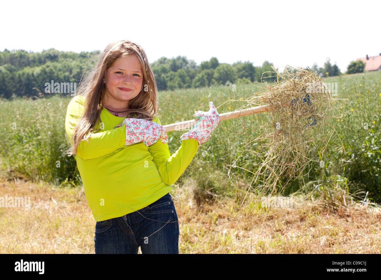 Girl, 8 years, bringing in hay Stock Photo