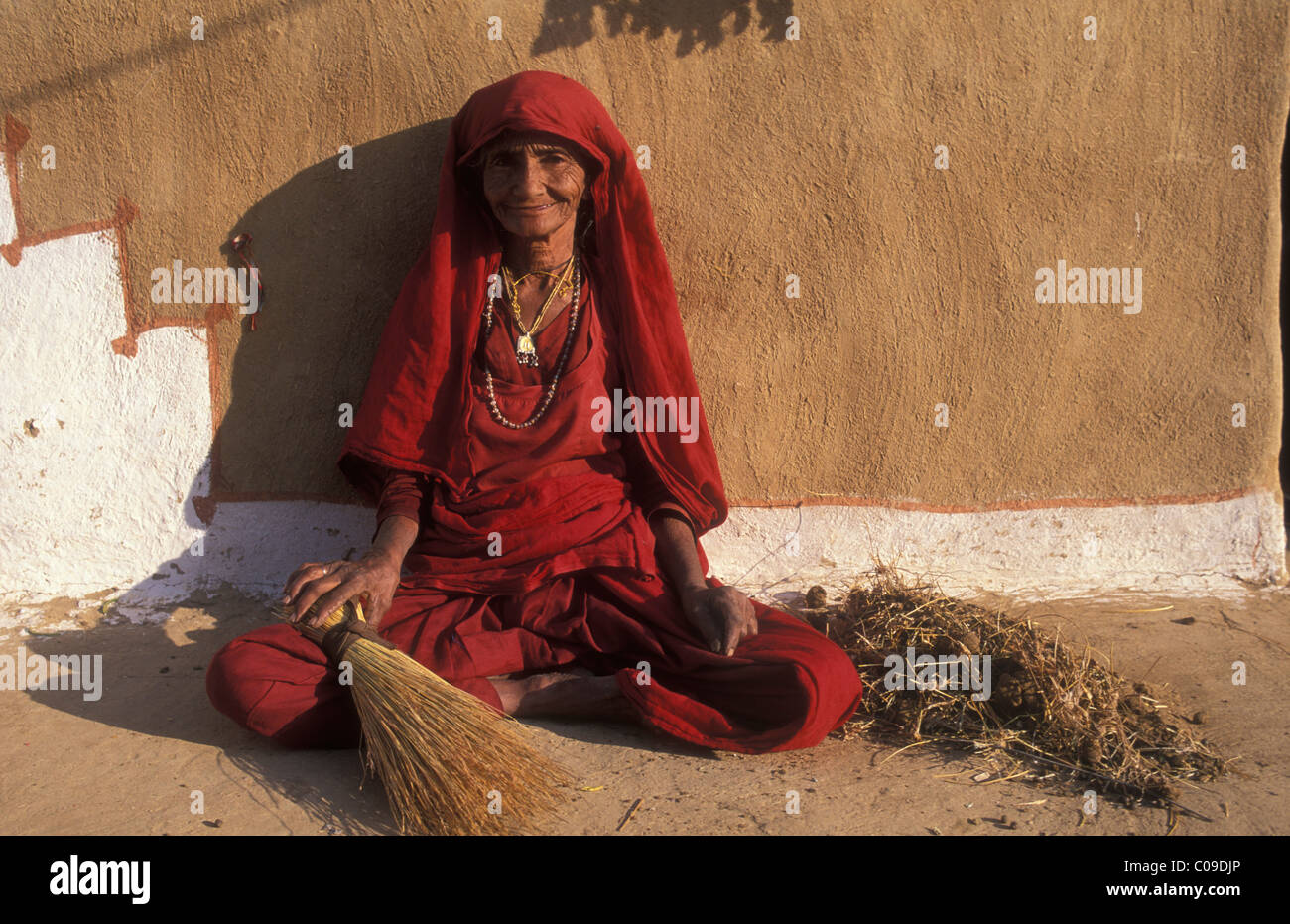 Old woman sitting in front of a house, Thar Desert, Rajasthan, India, Asia Stock Photo