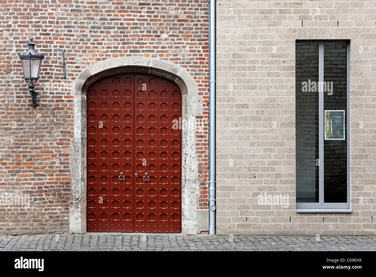 Medieval brick wall with gate side by side with a new wall with modern windows, Stiftsmuseum monastery museum, Xanten Stock Photo