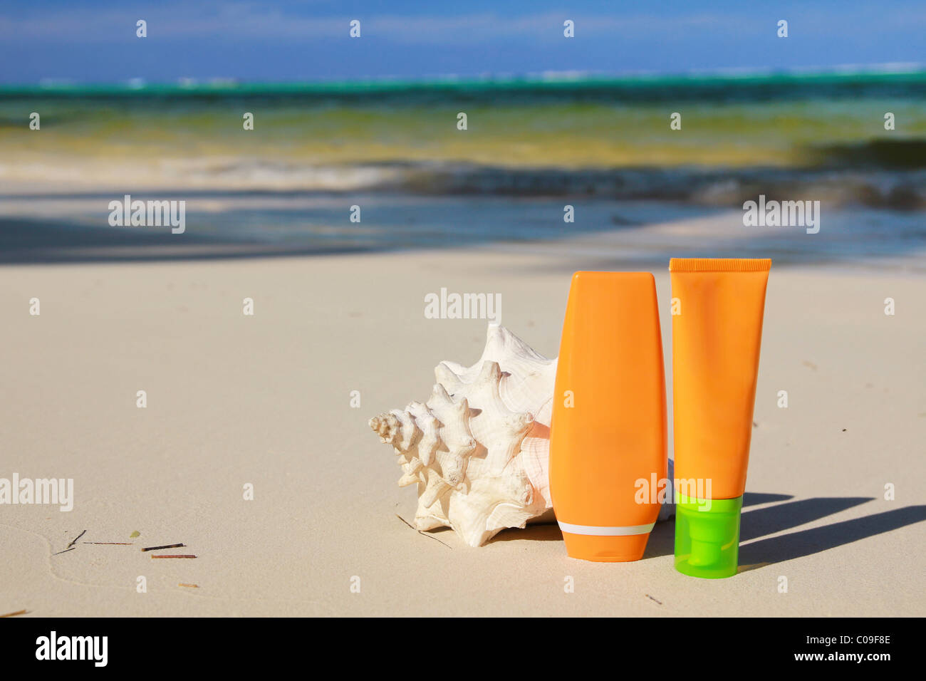 Sun protection tubes and seashell on caribbean beach Stock Photo