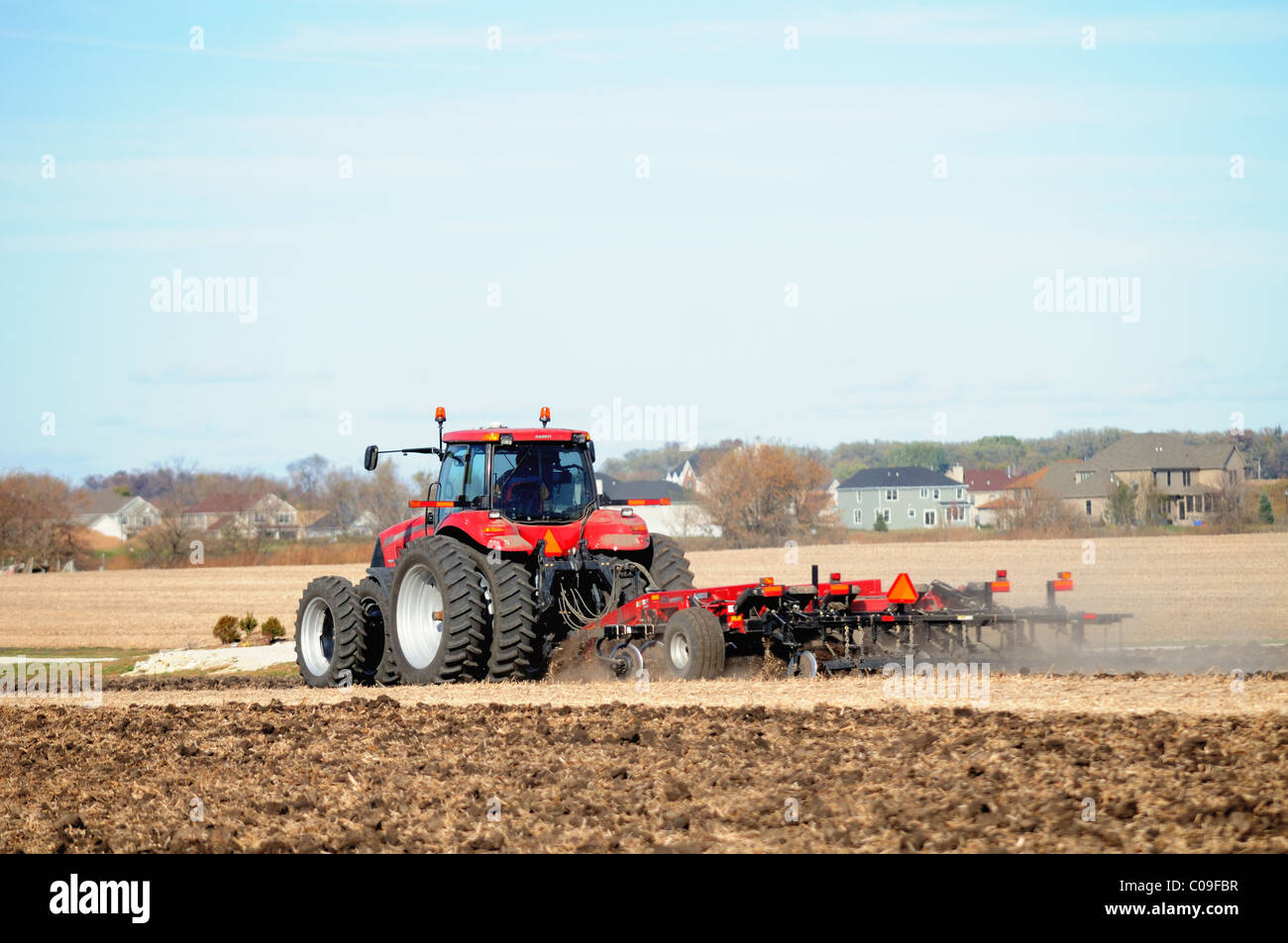 Tractor turning fields following harvesting crops Illinois farm where ...