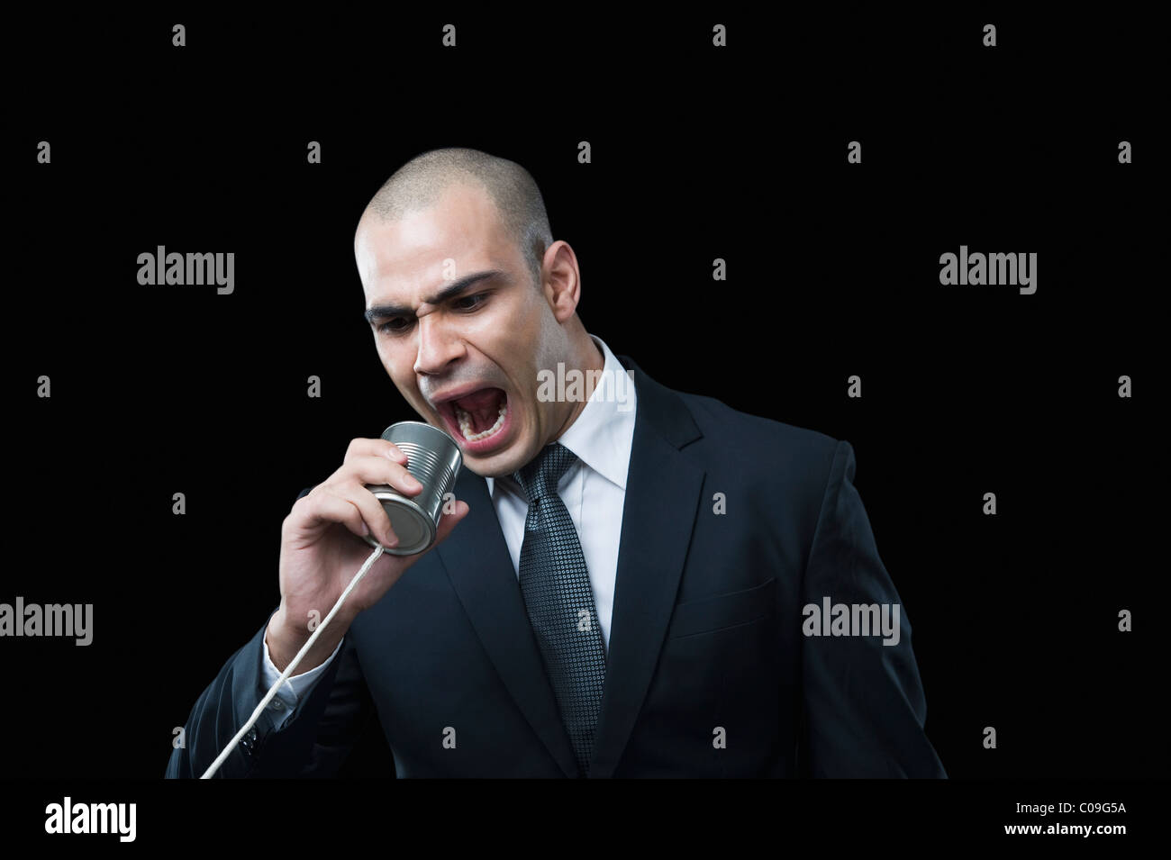 Businessman shouting on a tin can phone Stock Photo
