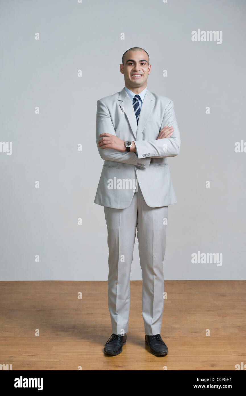 Businessman standing with his arms crossed and smiling Stock Photo - Alamy