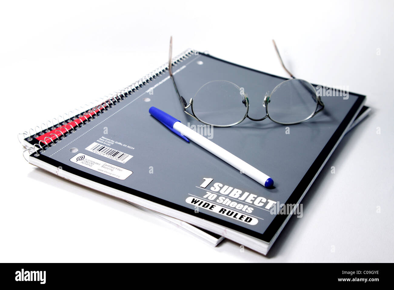 Spiral bound gray and red notebooks with pen and glasses Stock Photo