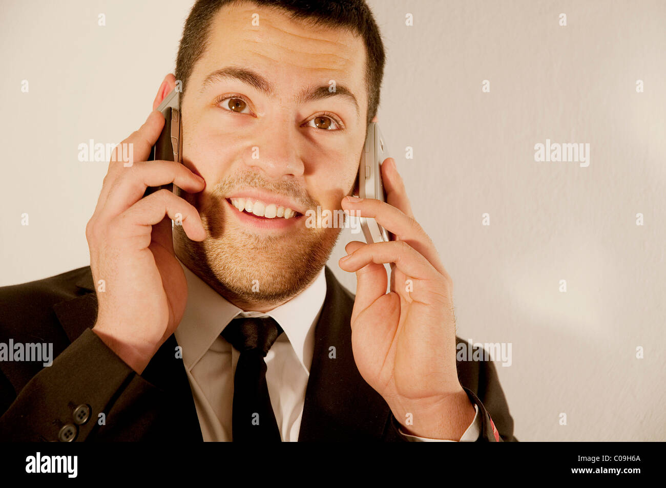 Young man using two mobile phones. Close view. Stock Photo