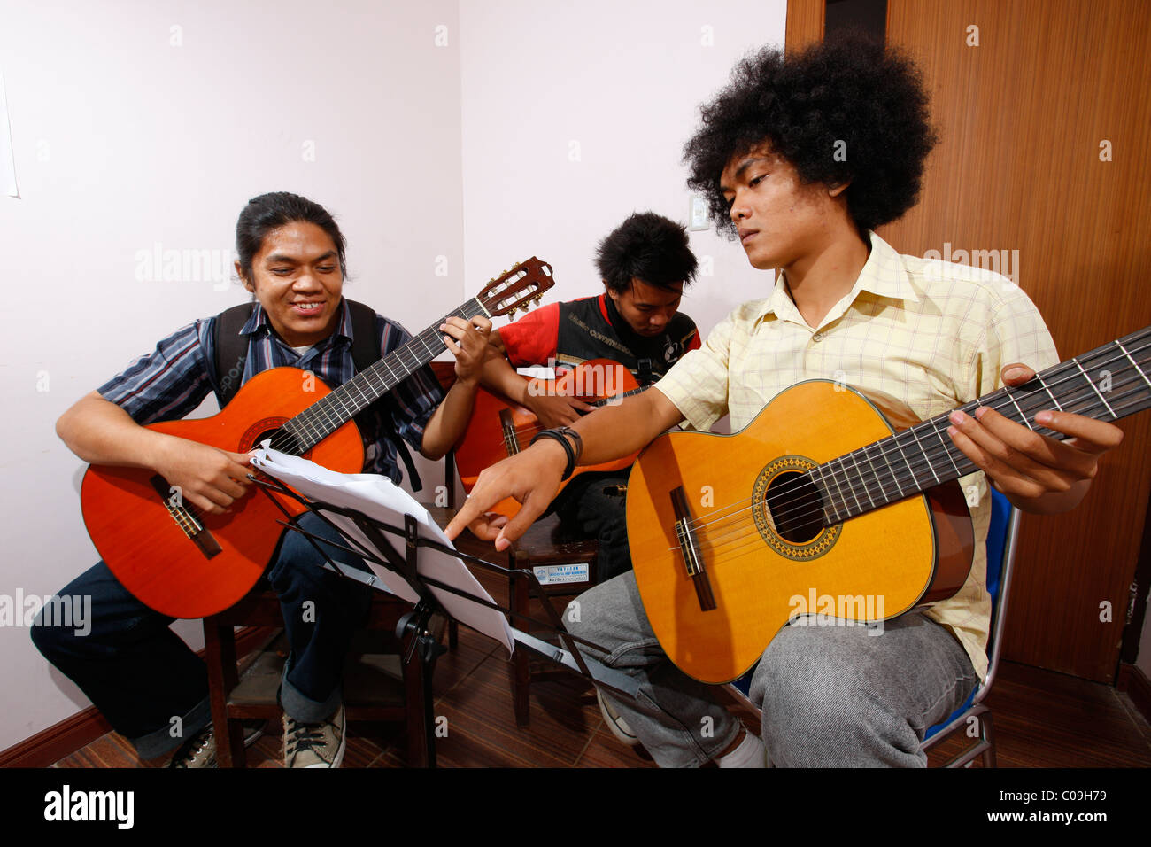 Students learning to play guitar, HKBP Nommensen University, Medan, Sumatra island, Indonesia, Asia Stock Photo