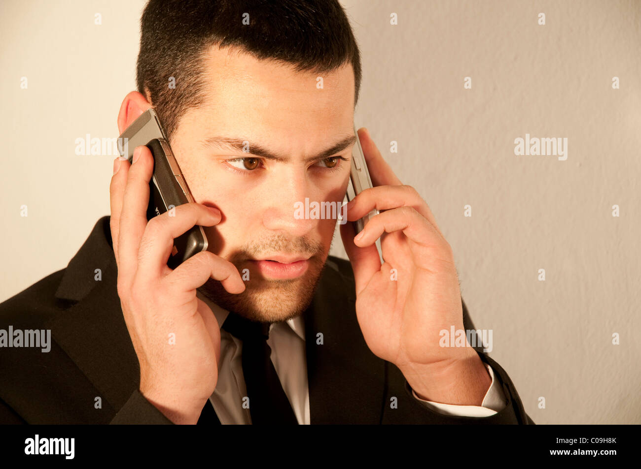 Young man using two mobile phones. Close view. Stock Photo