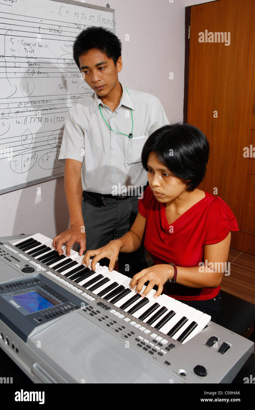 Student learning to play keyboard, HKBP Nommensen University, Medan, Sumatra island, Indonesia, Asia Stock Photo