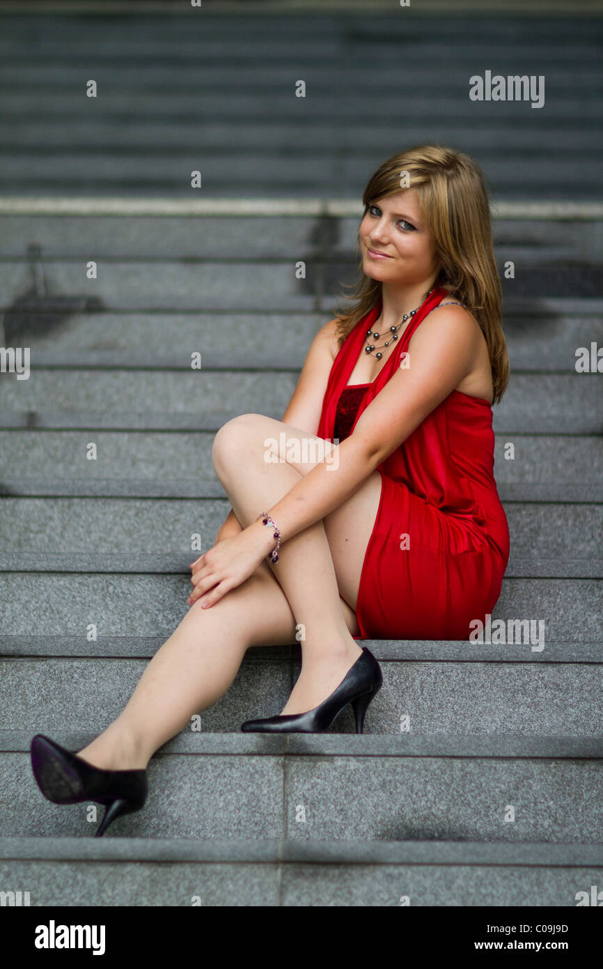 Young woman in a red dress and black high heels