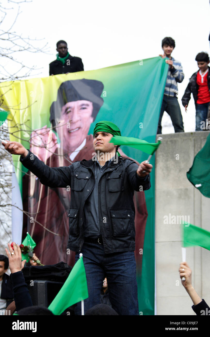Pro Colonel Gaddafi protester next to large banner Stock Photo