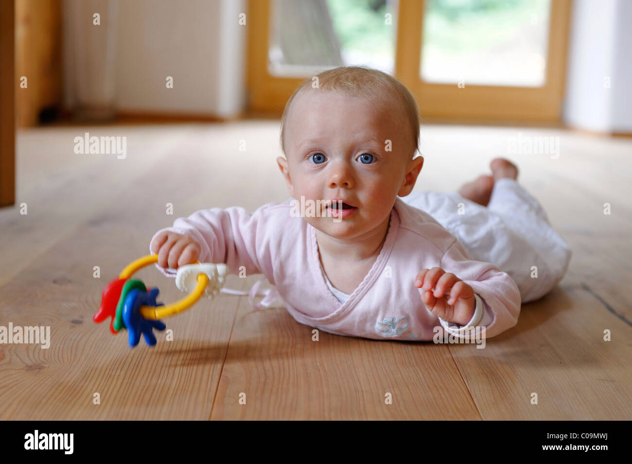 Small baby, 4 months, lying on her belly, with teether Stock Photo