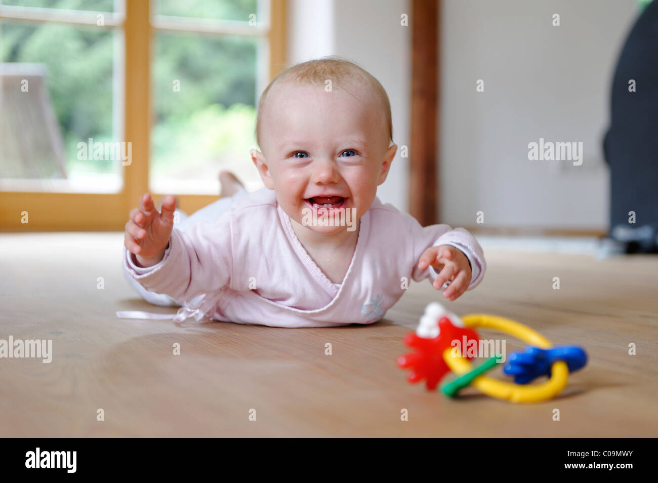 Small baby, 4 months, lying on her belly, with teether Stock Photo Alamy