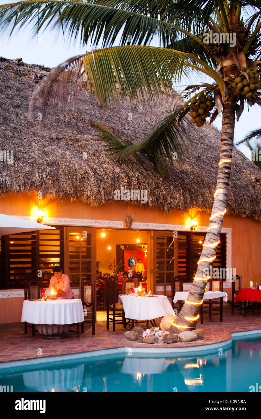 A restaurant is lit up near a pool at a luxury hotel in Belize. Stock Photo