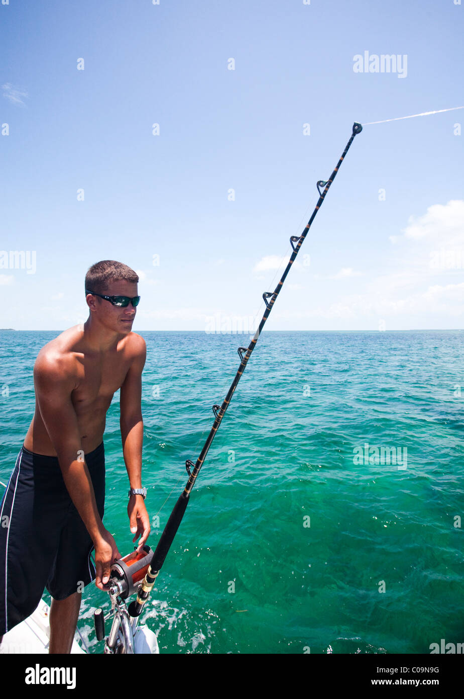 https://c8.alamy.com/comp/C09N9G/a-young-man-lets-fishing-line-out-of-his-reel-while-deep-sea-fishing-C09N9G.jpg