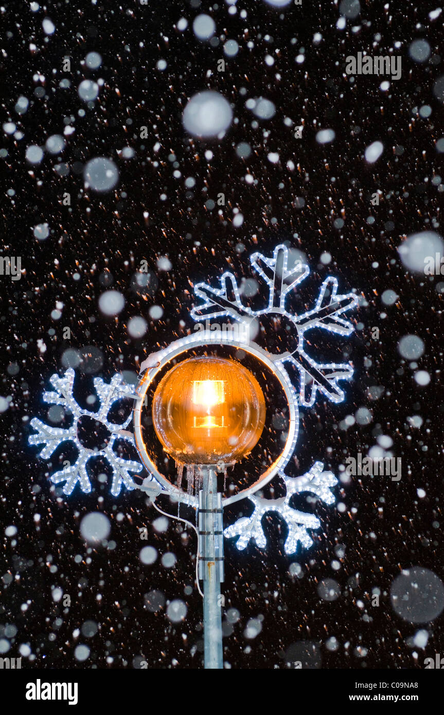 Christmas lights with snow flakes at night Stock Photo