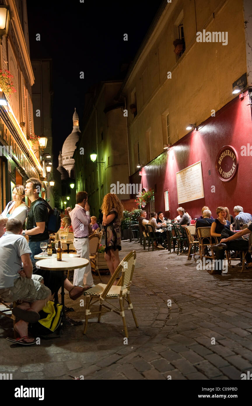 Busy alleyway near the Place du Tertre, in the back the dome of the Sacre Coeur basilica, Montmartre district, Paris Stock Photo
