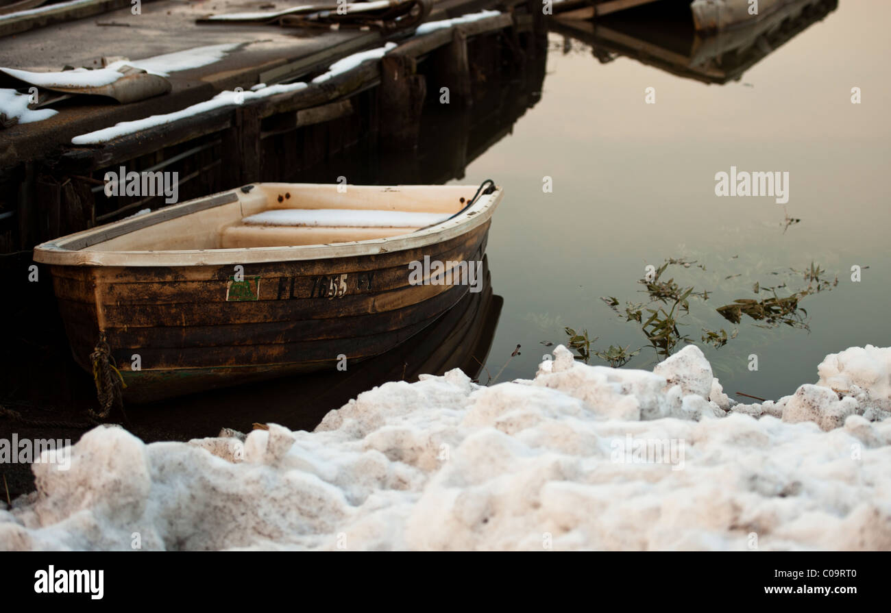 A serene winter landscape of a forgotten dinghy on the Potomac River in Virginia. USA Stock Photo