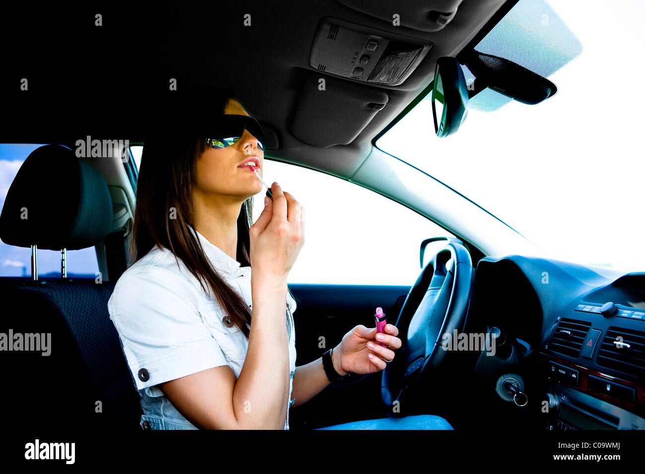 Young woman putting on makeup in the car Stock Photo Alamy
