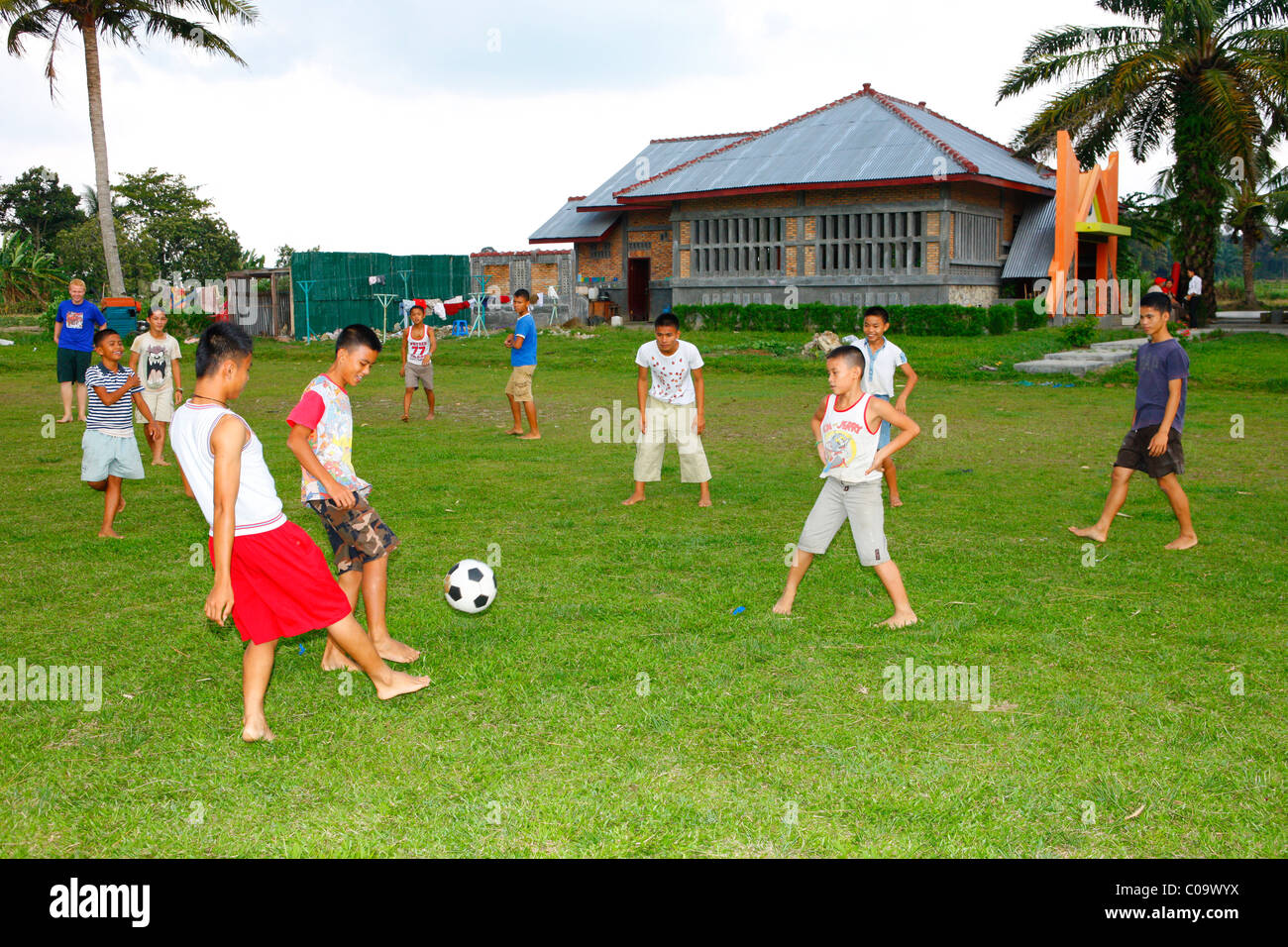 Children playing soccer on the sports field, Margaritha children's home, Marihat, Batak region, Sumatra island, Indonesia, Asia Stock Photo