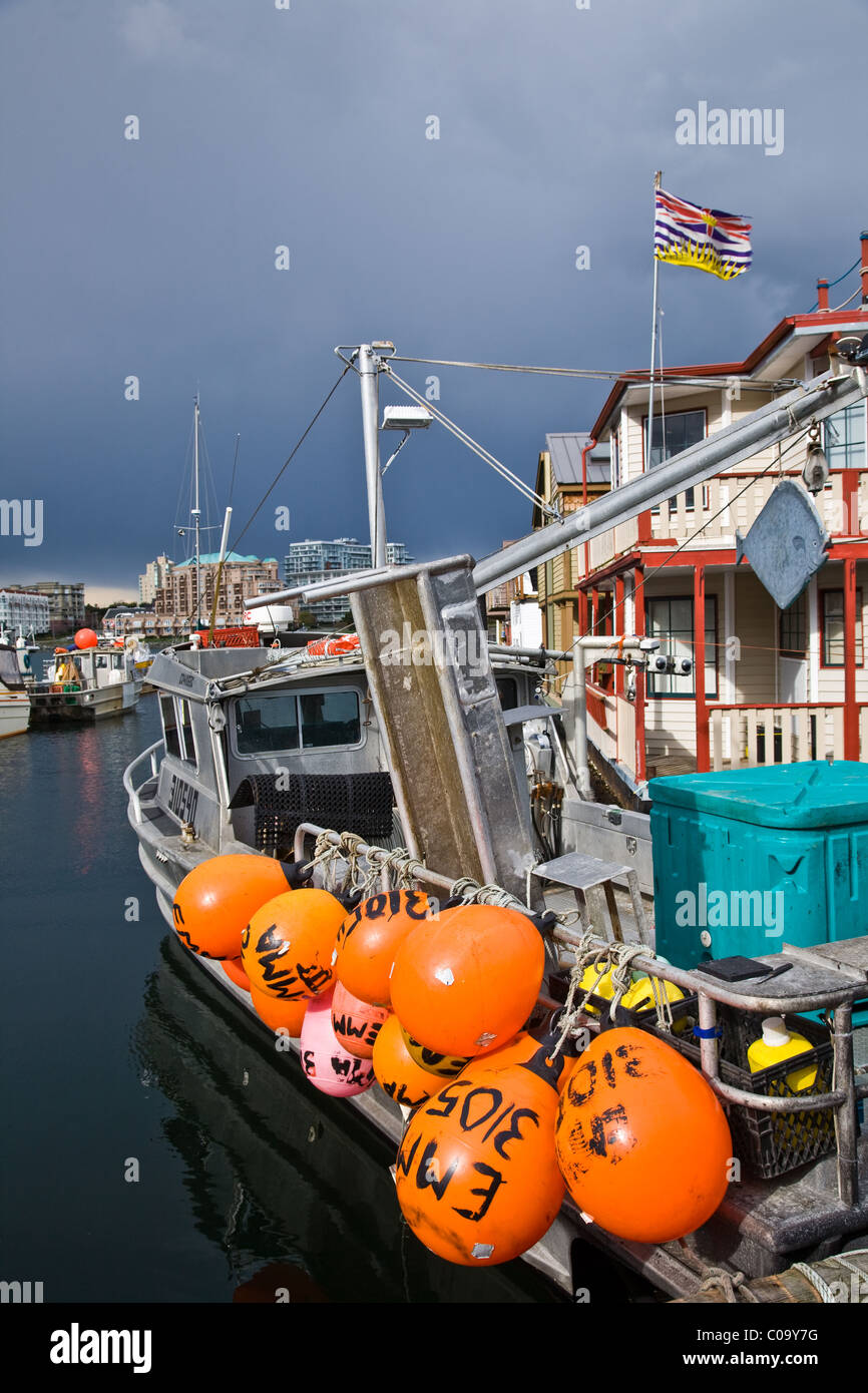 Orange net floats tethered to the side of a fishing vessel Stock Photo