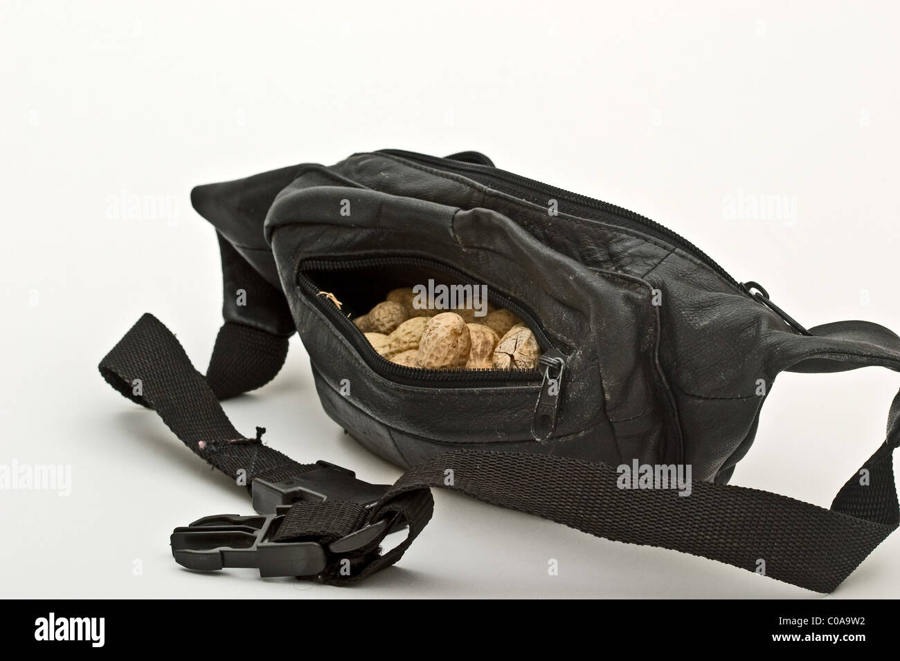 Black leather waist pouch filled with peanuts Stock Photo