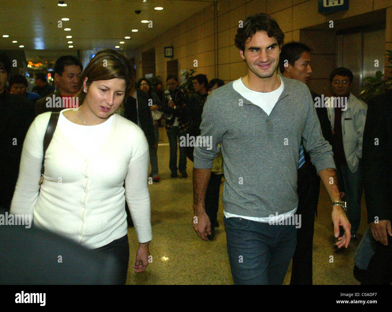 Tennis ace Roger Federer and his girlfriend and agent Mirka Vavrinec arrive at Shanghai International Airport for the Masters Stock Photo