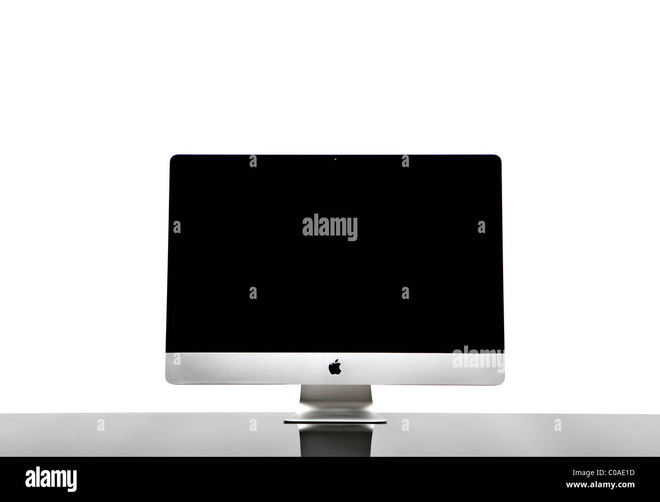 Elegant wireless computer isolated on a glass desk with a white background. Front View. Stock Photo