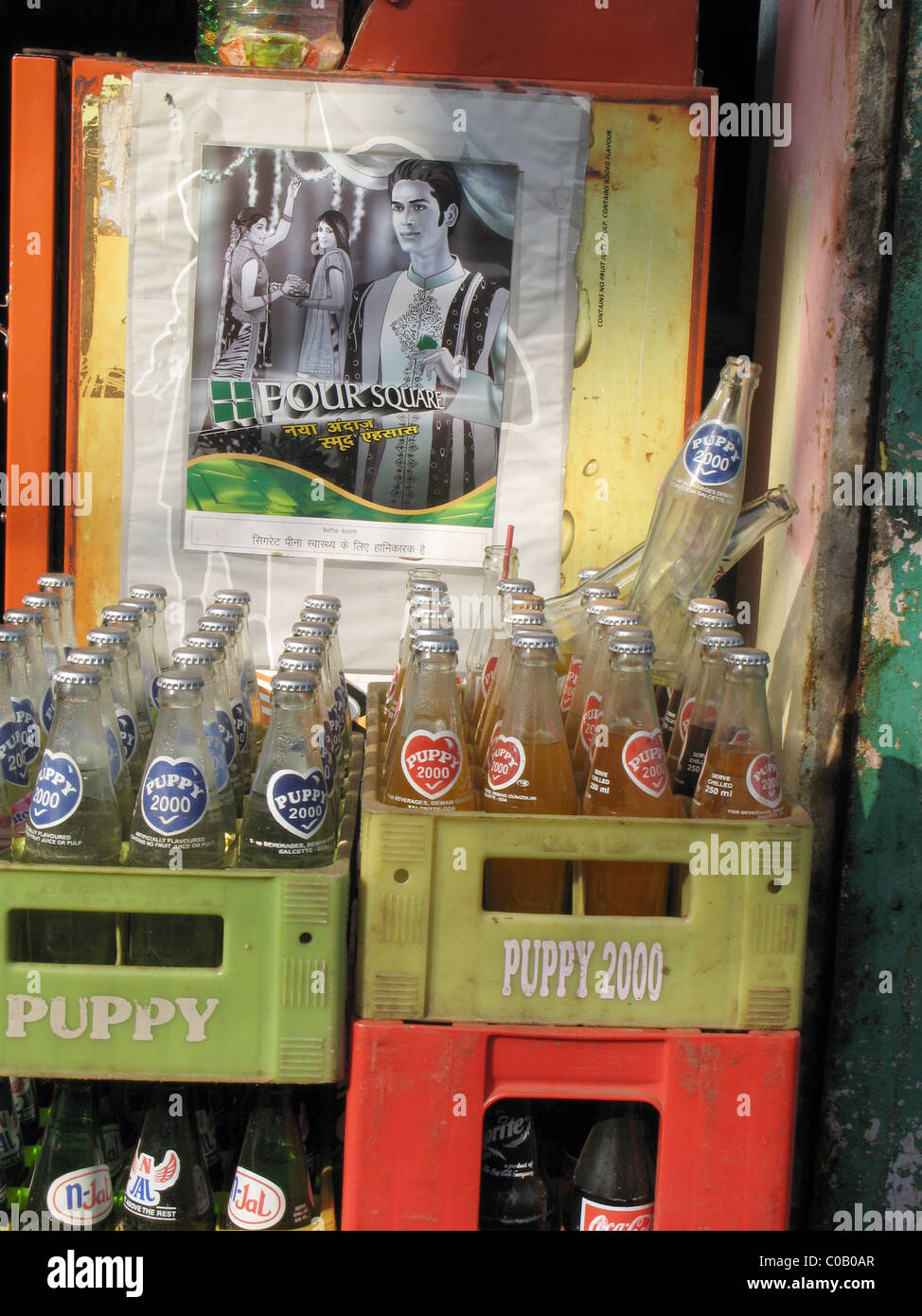 india. Crates of empty soft drink bottles and advertising poster in the