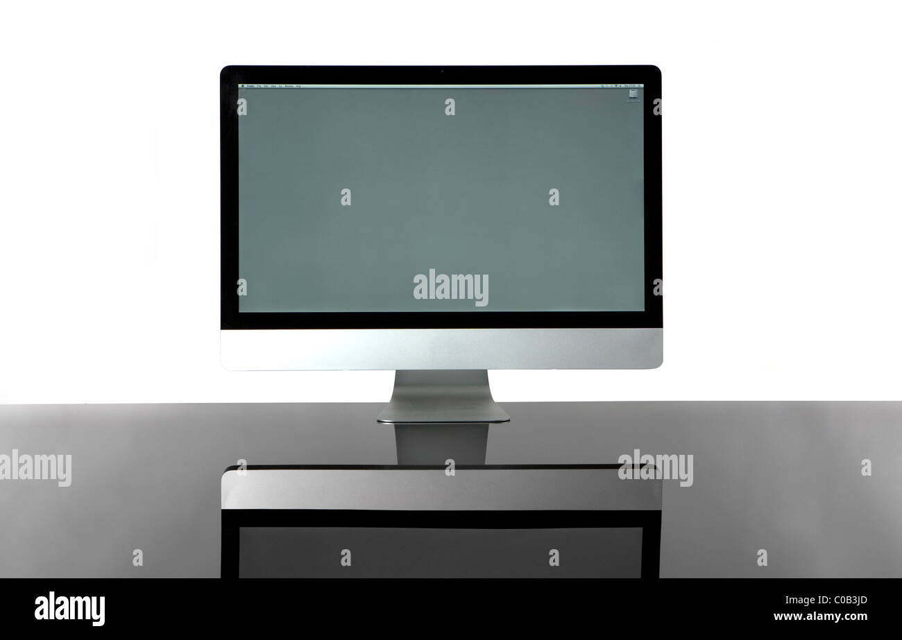 Elegant wireless computer isolated on a glass desk with a white background. Front View. Stock Photo