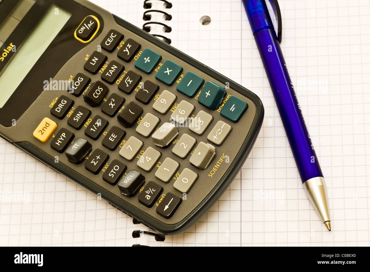 A broken calculator with missing keys, laid on a book with a pen Stock  Photo - Alamy