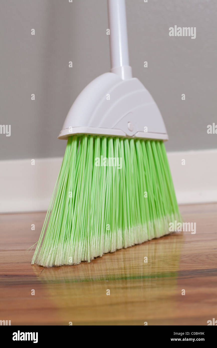 Green Broom on a Hardwood Floor Stock Photo