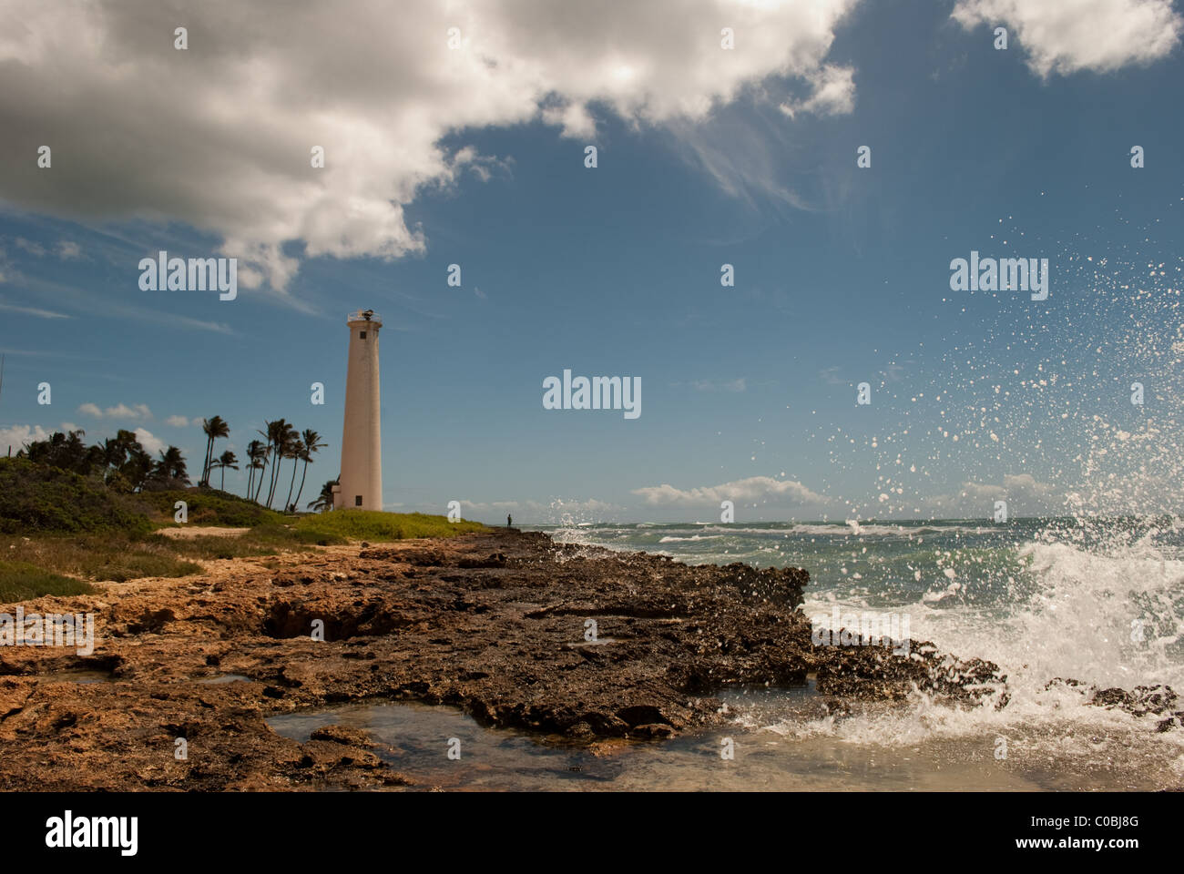 Large wave crashing into rocky coast. Barber's Point Lighthouse, Oahu Hawaii. Stock Photo