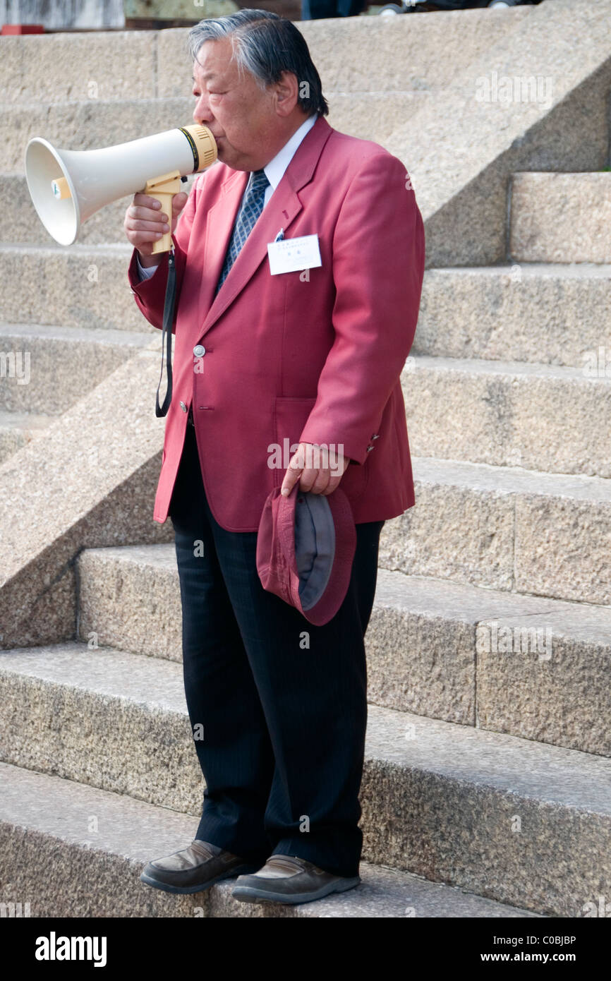 Tour guide with a megaphone on the steps leading up to the Great Buddha at Tōdai-ji, Nara, Japan Stock Photo