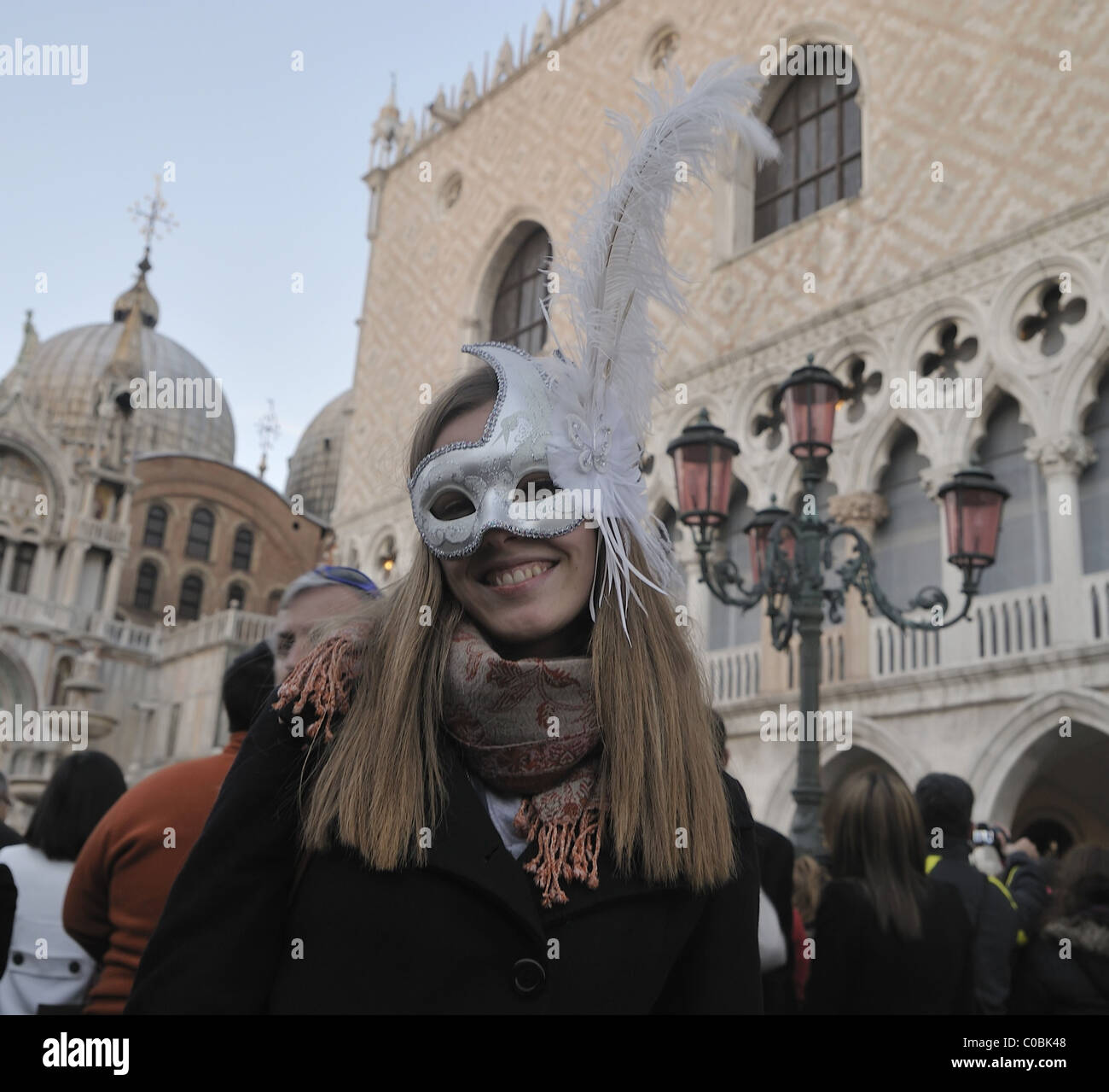 A woman wearing Carnival costume and mask poses in St Mark Square Stock Photo